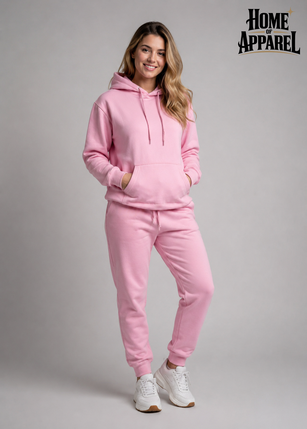 A woman wearing pink pullover hoodie and jogger pants, paired with white sneakers Image