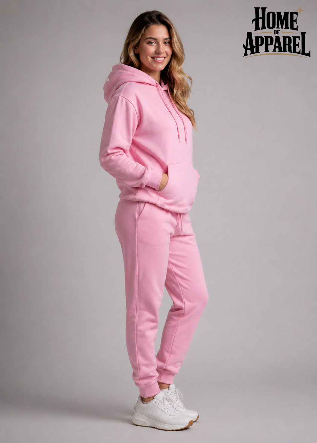 A woman wearing pink pullover hoodie and jogger pants, paired with white sneakers